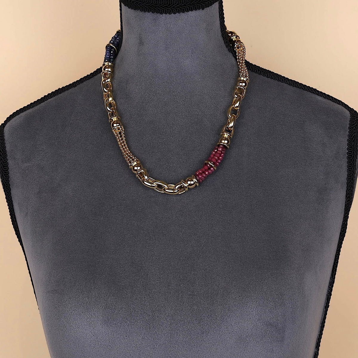Exclusive italienische Kette in 750er Gelbgold mit Rubinen und blauen Saphiren an einer dunklen großen Büste