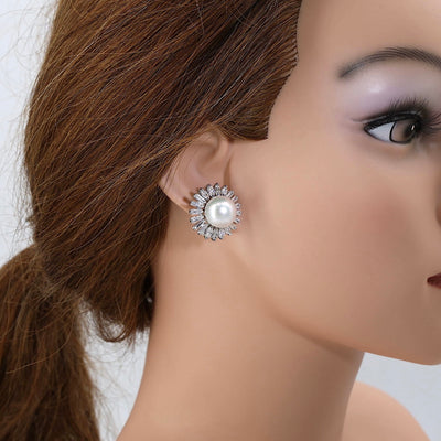 Paar exclusive Ohrstecker in 750er Weißgold mit je einer Südsee-Zuchtperle und insgesamt ca. 2,9 ct Diamanten, einzelnd am Ohr einer Puppe