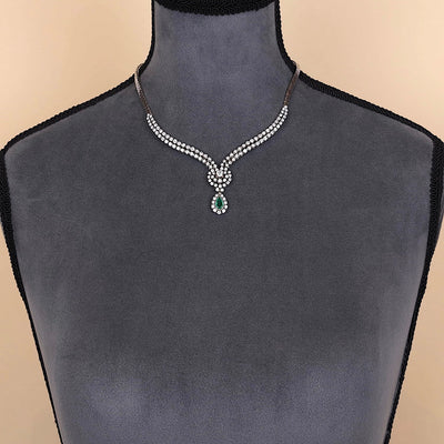 Juwelen-Collier in 750er Weißgold mit ca. 7,0 ct Brillanten und einem Smaragd, an einer dunklen Büste