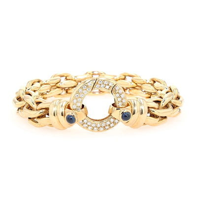 Peter Fischer - großes Gliederarmband von in 585er Gelbgold mit Brillanten und blauen Saphir-Cabochons, liegend frontal Schloss aufrecht