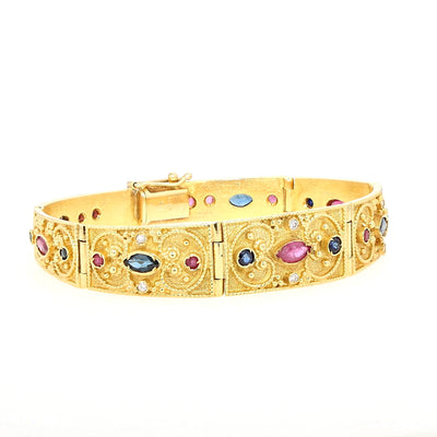 Armband in 750er Gelbgold mit Brillanten, Rubinen und blauen Saphiren, liegend geschlossen rechts gedreht